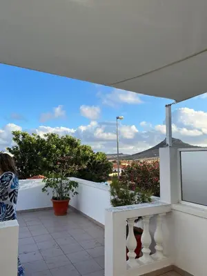 a woman standing on a balcony looking at the view at Casa Bambi in Porto Santo