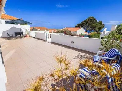 a patio with two chairs and an umbrella on a house at Casa Bambi in Porto Santo