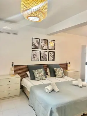 a bedroom with two beds and a chandelier at Casa Bambi in Porto Santo