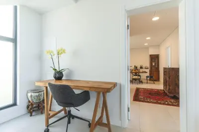 a dining room with a wooden table and a chair at Sapphire Sands by Atlantic Holiday in Estreito da Calheta