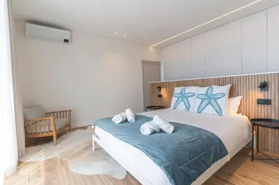 a bedroom with a bed with blue and white pillows at Sapphire Sands by Atlantic Holiday in Estreito da Calheta