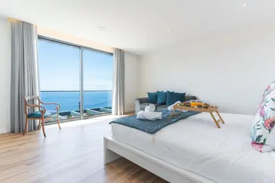 a bedroom with a bed with a view of the ocean at Sapphire Sands by Atlantic Holiday in Estreito da Calheta