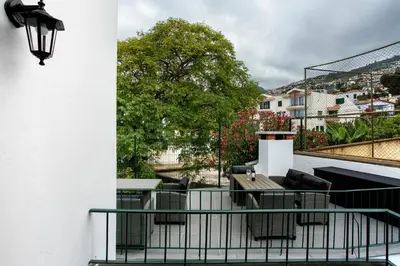 a balcony with a table and chairs on a building at Casa Caminho do Palheiro - Funchal in Funchal