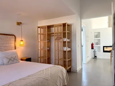 a bedroom with a bed and wooden book shelves at Casa Amado in Carrapateira