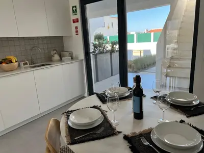 a table with glasses and a bottle of wine on it at Casa Amado in Carrapateira