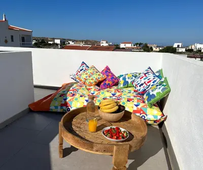 a table with a bowl of fruit on a balcony at Casa Amado in Carrapateira