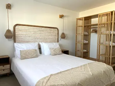 a bedroom with a bed with white sheets and pillows at Casa Amado in Carrapateira