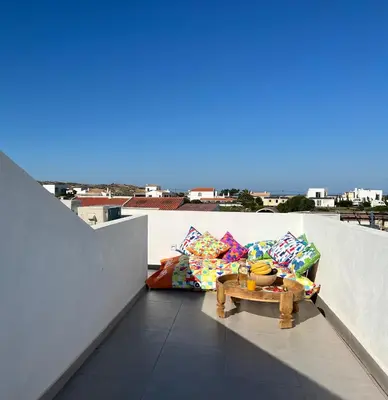 a balcony with pillows and a table on a roof at Casa Amado in Carrapateira