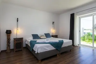 a bedroom with a bed and a large window at D13 - Eiras Velhas Holiday House in Almádena in Almádena