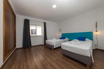 a hotel room with two beds and a window at D13 - Eiras Velhas Holiday House in Almádena in Almádena