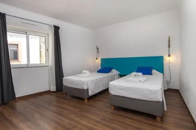 a room with two beds and a window at D13 - Eiras Velhas Holiday House in Almádena in Almádena