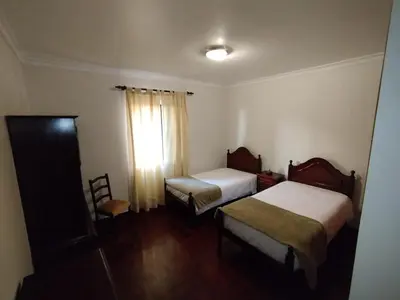 a small room with two beds and a window at MCR Calheta in Calheta