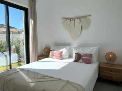 a bedroom with a white bed with pillows and a window at Casa Amoreira in Carrapateira