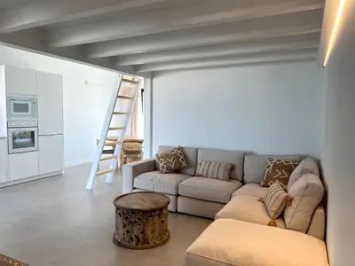 a living room with a couch and a stool at Casa Amoreira in Carrapateira