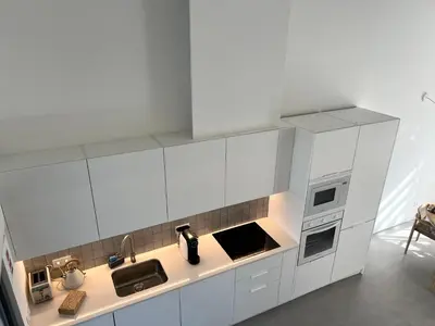 a white kitchen with white cabinets and appliances at Casa Amoreira in Carrapateira
