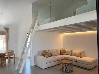 a living room with a couch and a loft bed at Casa Amoreira in Carrapateira