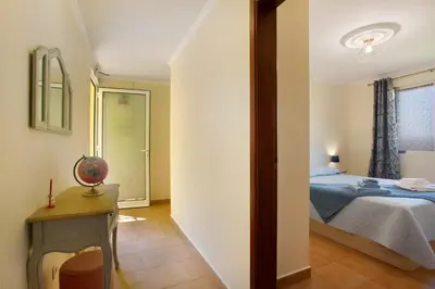 a bedroom with a bed and a table and a window at Levada Residence in Funchal