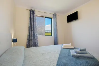 a bedroom with a bed and a window at Levada Residence in Funchal