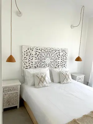 a bedroom with a white bed with white sheets and pillows at Casa Arrifana in Carrapateira