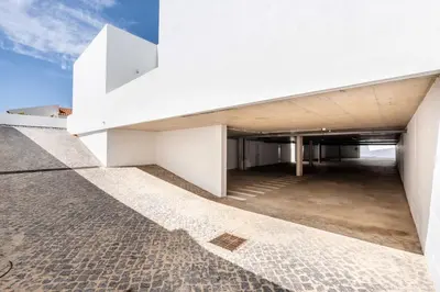 a white building with a parking lot at Casa Arrifana in Carrapateira