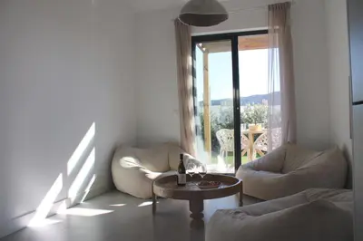 a living room with two chairs and a table and a window at Casa Arrifana in Carrapateira