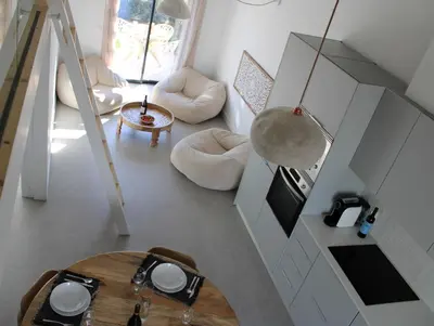 a living room with a table and a kitchen at Casa Arrifana in Carrapateira