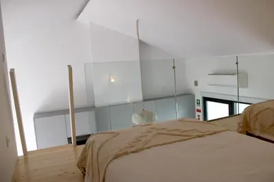 a bedroom with a bed and a glass wall at Casa Arrifana in Carrapateira