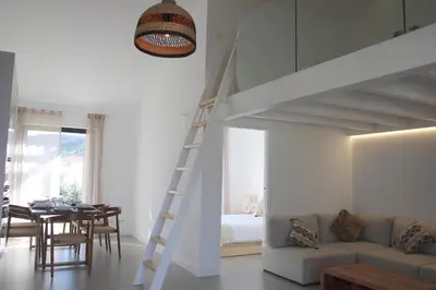 a living room with a white loft bed and a table at Casa Castelejo in Bordeira
