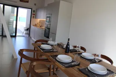 a dining room table with plates and wine glasses at Casa Castelejo in Bordeira