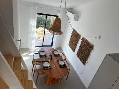 a dining room with a wooden table and chairs at Casa Cordoama in Bordeira