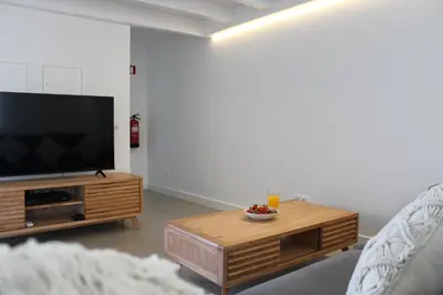 a living room with a television and a coffee table at Casa Cordoama in Bordeira