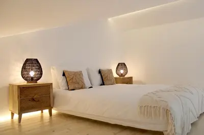 a bedroom with a white bed with two night stands at Casa Cordoama in Bordeira