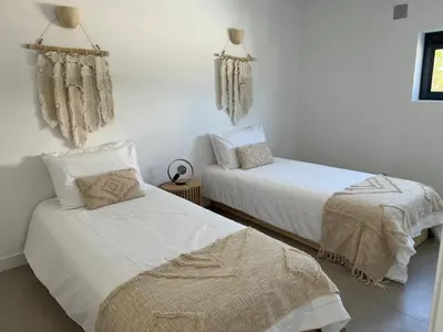two beds in a room with white walls at Casa Bordeira in Bordeira