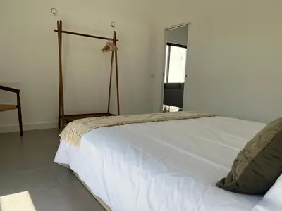 a bedroom with a white bed and a mirror at Casa Bordeira in Bordeira