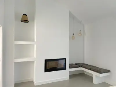 a living room with a tv on a white wall at Casa Bordeira in Bordeira