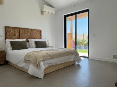 a bedroom with a large bed and a large window at Casa Bordeira in Bordeira