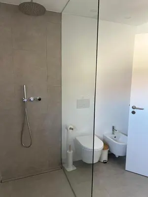 a bathroom with a shower and a toilet and a sink at Casa Bordeira in Bordeira
