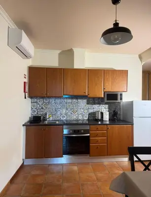 a kitchen with wooden cabinets and a stove at Old Zone Apartments 1A in Funchal