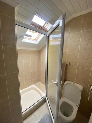 a bathroom with a toilet and a shower with a skylight at Casa do sol in Santa Cruz