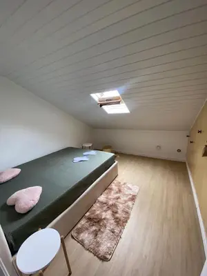 a bedroom with a green bed in a attic at Casa do sol in Santa Cruz