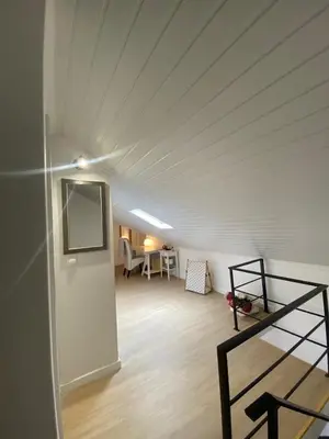 an attic room with a white ceiling and a desk at Casa do sol in Santa Cruz