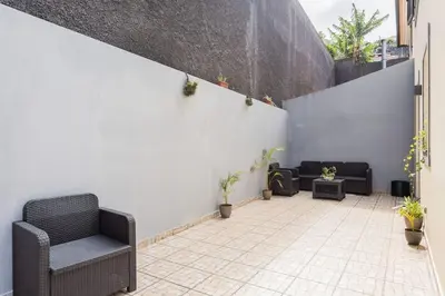 a patio with chairs and a wall with plants at Machico Oasis in Machico