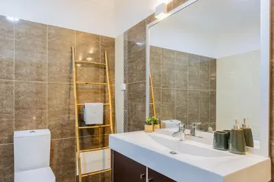 a bathroom with a sink and a toilet and a mirror at Machico Oasis in Machico