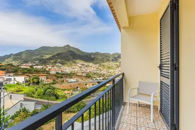 a balcony with a chair and a view of a mountain at Machico Oasis in Machico