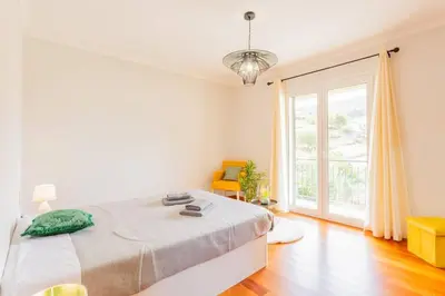 a bedroom with a bed and a large window at Machico Oasis in Machico