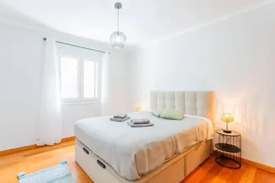 a white bedroom with a large bed in a room at Machico Oasis in Machico