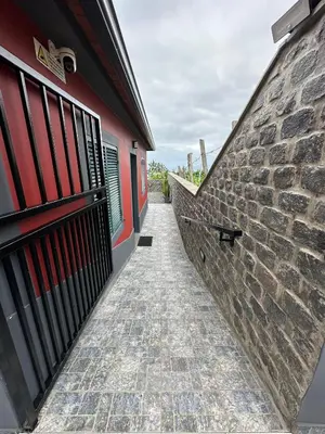 a brick alleyway next to a building with a gate at Vila Romana in São Vicente