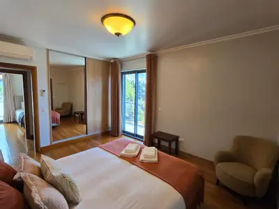 a bedroom with a bed and a chair and a mirror at Penthouse in the center of Funchal in Funchal