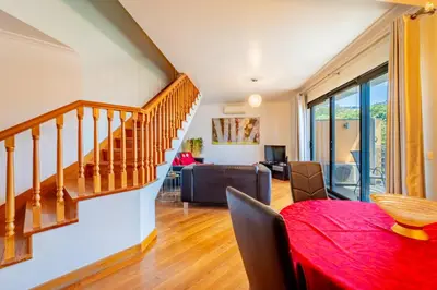 a living room with a staircase and a dining room at Penthouse in the center of Funchal in Funchal