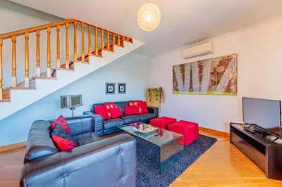 a living room with a leather couch and red pillows at Penthouse in the center of Funchal in Funchal